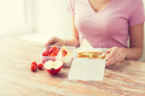 close up of woman with food in plastic container Stock photo © dolgachov