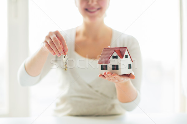 Stock photo: close up of woman holding house model and keys