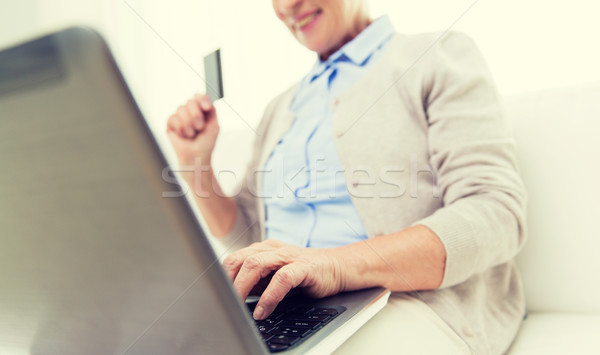 senior woman with laptop and credit card at home Stock photo © dolgachov