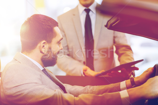 happy man with car dealer in auto show or salon Stock photo © dolgachov