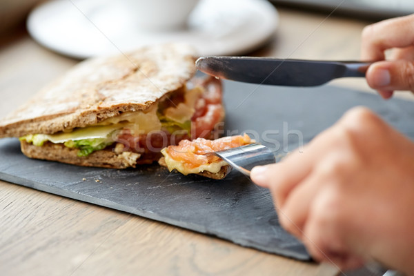 Személy eszik lazac panini szendvics éttermi étel Stock fotó © dolgachov