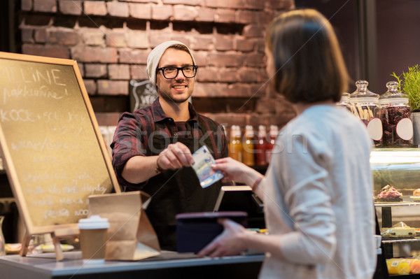happy barman and woman paying money at cafe Stock photo © dolgachov
