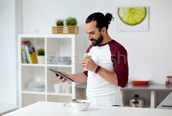 man with tablet pc eating breakfast at home Stock photo © dolgachov