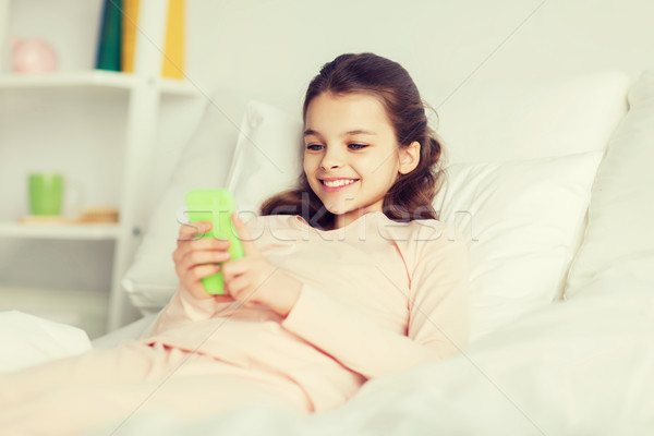 Gelukkig meisje bed smartphone home mensen kinderen Stockfoto © dolgachov