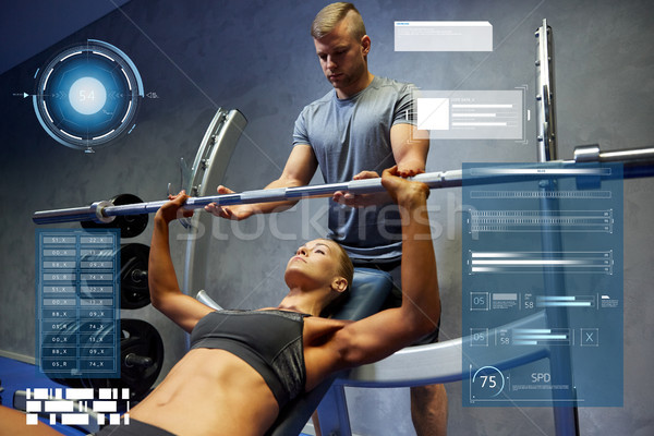 man and woman with barbell flexing muscles in gym Stock photo © dolgachov