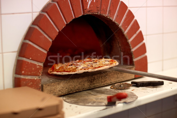 peel taking baked pizza out of oven at pizzeria Stock photo © dolgachov