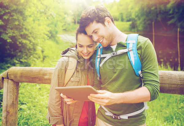 happy couple with backpacks and tablet pc outdoors Stock photo © dolgachov