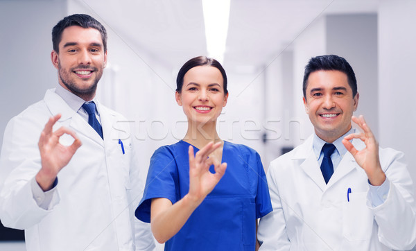 group of medics at hospital showing ok hand sign Stock photo © dolgachov
