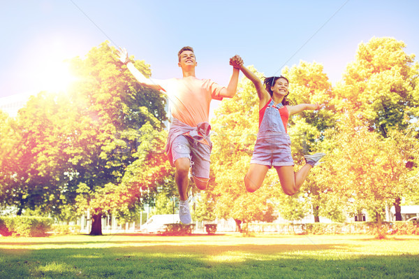 happy teenage couple jumping at summer park Stock photo © dolgachov