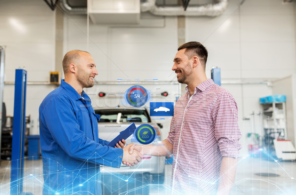 auto mechanic and man shaking hands at car shop Stock photo © dolgachov