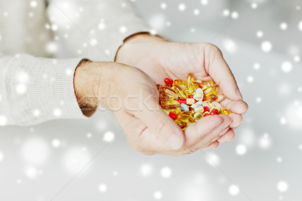 close up of senior man hands holding pills Stock photo © dolgachov