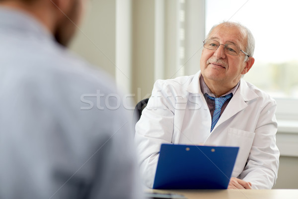 senior doctor talking to male patient at hospital Stock photo © dolgachov