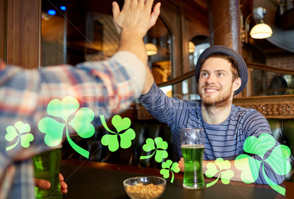 friends with green beer making high five at pub Stock photo © dolgachov