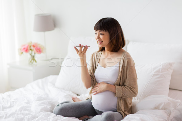 Donna incinta voce smartphone gravidanza maternità Foto d'archivio © dolgachov