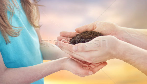 close up of father and daughter hands holding soil Stock photo © dolgachov