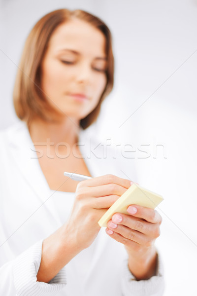 businesswoman writing on sticky note Stock photo © dolgachov