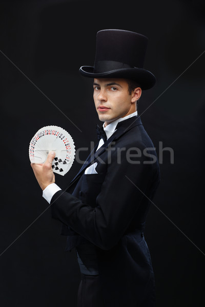 magician showing trick with playing cards Stock photo © dolgachov