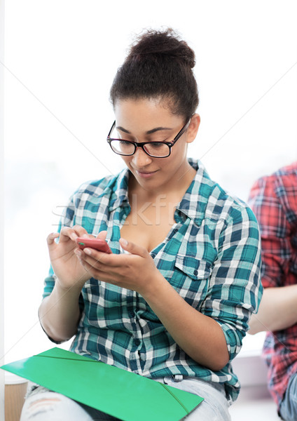african student browsing in smartphone at school Stock photo © dolgachov