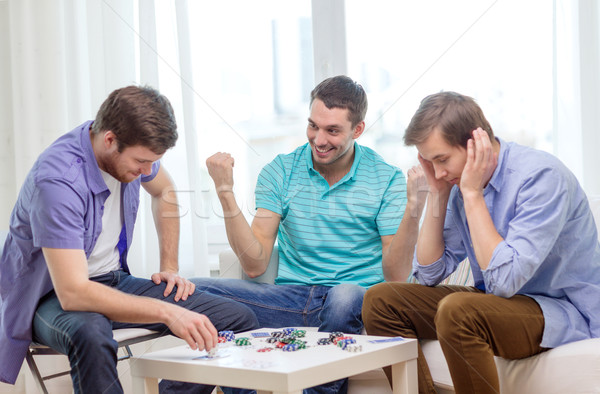 Felice tre maschio amici giocare poker Foto d'archivio © dolgachov