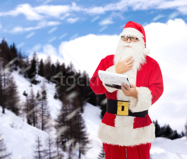 man in costume of santa claus with notepad Stock photo © dolgachov