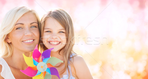 happy mother and little girl with pinwheel toy Stock photo © dolgachov