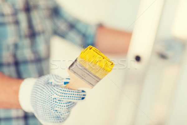 Stock photo: close up of male in gloves holding paintbrush