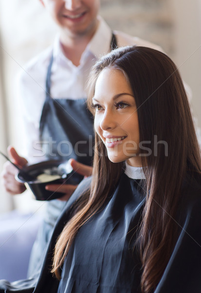 happy young woman coloring hair at salon Stock photo © dolgachov