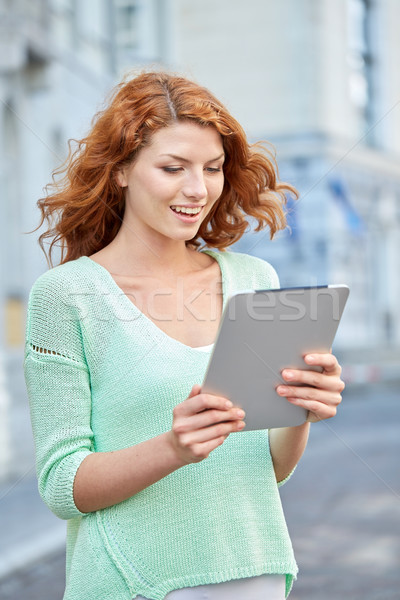 smiling teenage girl with tablet pc on city street Stock photo © dolgachov