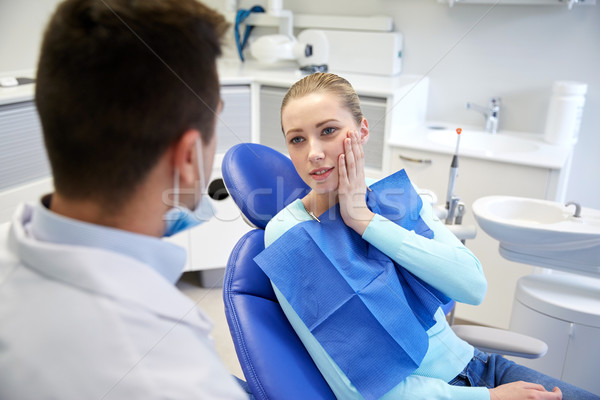 male dentist with woman patient at clinic Stock photo © dolgachov