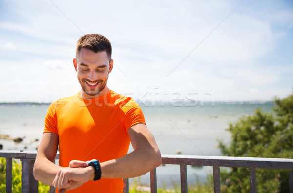 Sorridente moço inteligente beira-mar fitness Foto stock © dolgachov