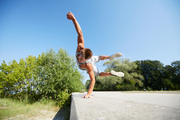 sporty young man jumping in summer park Stock photo © dolgachov