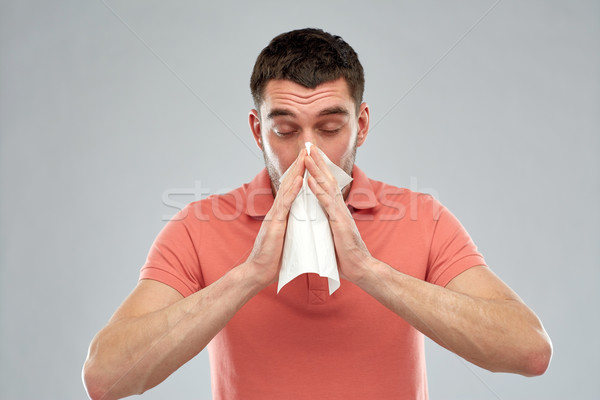 sick man with paper napkin blowing nose Stock photo © dolgachov