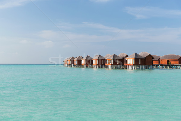 bungalow huts in sea water on exotic resort beach Stock photo © dolgachov