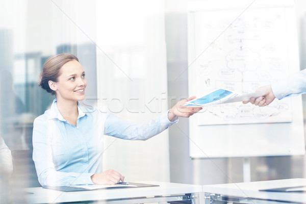 businesswoman taking papers from someone in office Stock photo © dolgachov