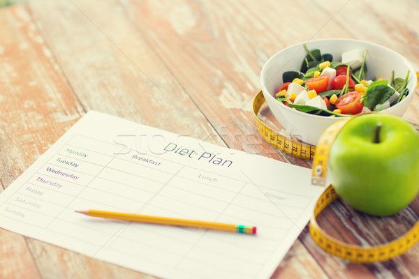 close up of diet plan and food on table Stock photo © dolgachov
