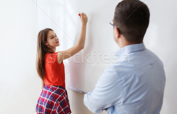 student writing on board and teacher at school Stock photo © dolgachov