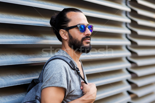 man with backpack standing at city street wall Stock photo © dolgachov