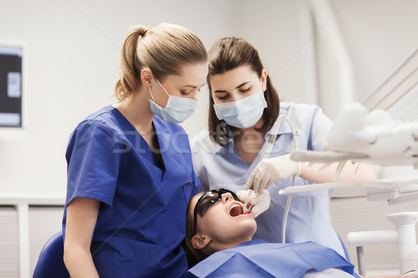 female dentists treating patient girl teeth Stock photo © dolgachov