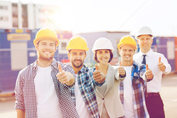 Stock photo: group of smiling builders in hardhats outdoors