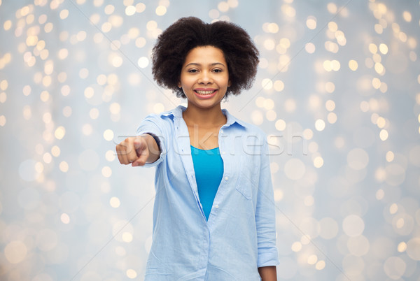 happy african woman pointing finger to you Stock photo © dolgachov