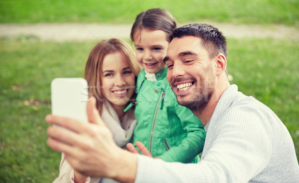 happy family taking selfie by smartphone outdoors Stock photo © dolgachov