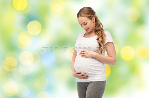 happy pregnant woman touching her big belly Stock photo © dolgachov