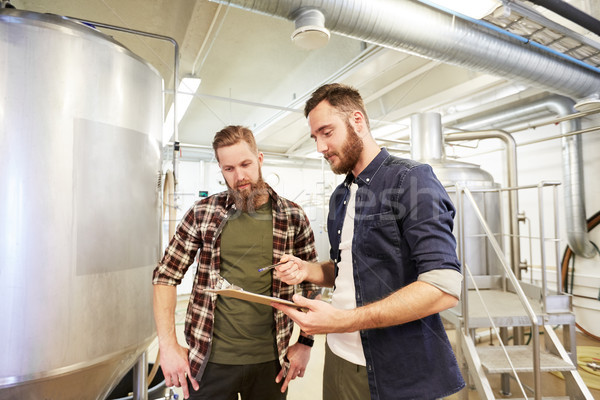 men with clipboard at brewery or beer plant Stock photo © dolgachov