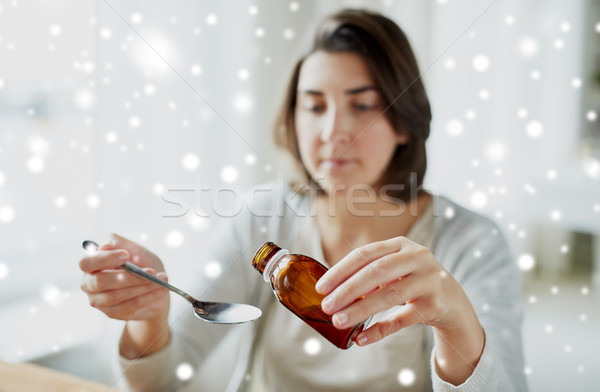 ill woman pouring medication from bottle to spoon Stock photo © dolgachov