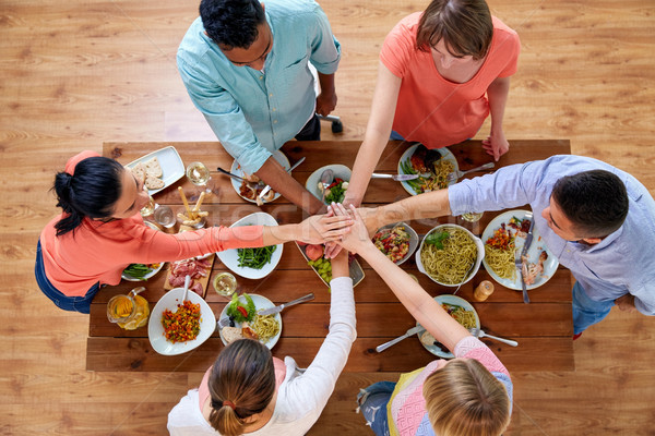 people holding hands together over table with food Stock photo © dolgachov