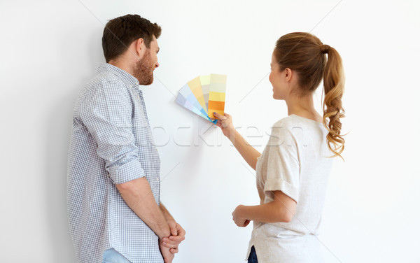 happy couple with color samples at new home Stock photo © dolgachov