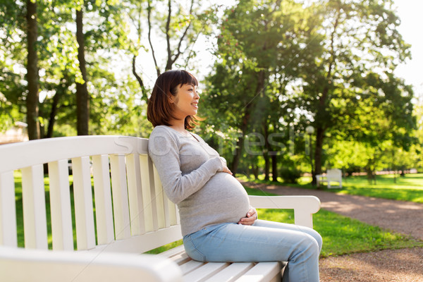 happy pregnant asian woman sitting on park bench Stock photo © dolgachov