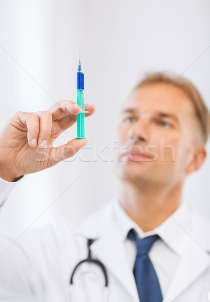 Stock photo: male doctor holding syringe with injection