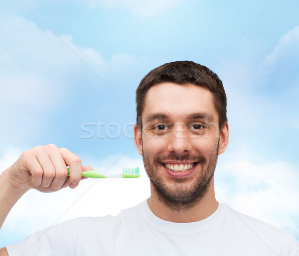 Glimlachend jonge man tandenborstel gezondheid schoonheid hemel Stockfoto © dolgachov