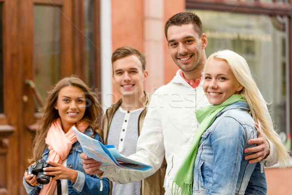 group of smiling friends with map and photocamera Stock photo © dolgachov